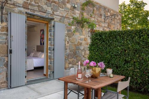 a wooden table with flowers on it next to a stone wall at Massoni Wine Relais in Peschiera del Garda
