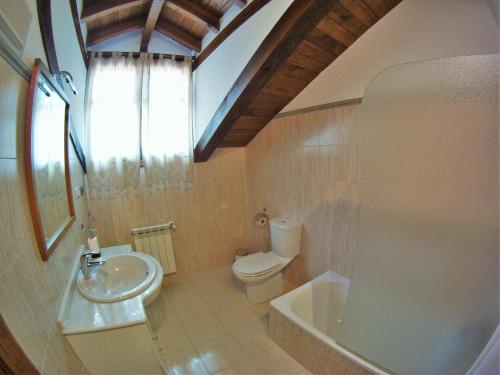a bathroom with a sink and a toilet and a tub at Viviendas Rurales El Cantón in Cucayo