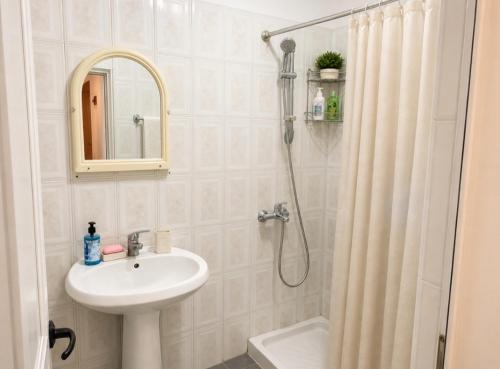 a white bathroom with a sink and a shower at Beautiful Sea View Borsh in Borsh