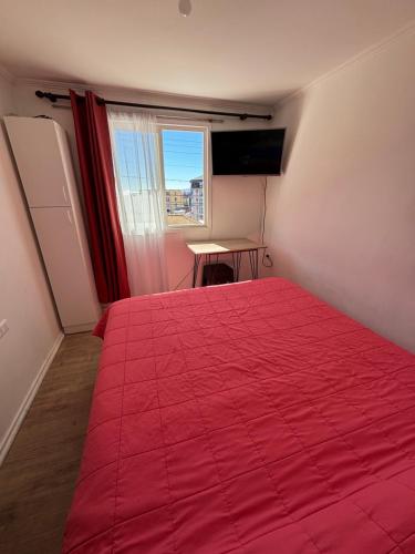 a bedroom with a red bed with a red blanket at Barros Borgoño 2 Departamento in Valparaíso