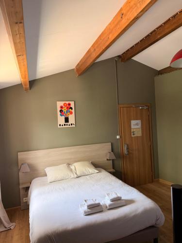 a bedroom with a bed with two towels on it at Hotel Clair de Lune in Zonza