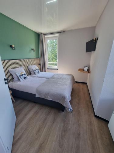 a bedroom with a bed and a window at L'Auberge d'Eygliers in Eygliers