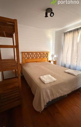 a bedroom with a bed with two towels on it at Cabañas Portofino todo incluido in Ramallo