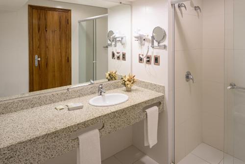 a bathroom with a sink and a shower at Bourbon Convention Hotel Santos in Santos