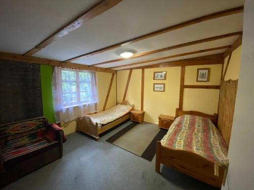 a small room with two beds and a window at Czereśniowy Dom dom na imprezy kawalerskie bunkry warsztaty in Goruńsko