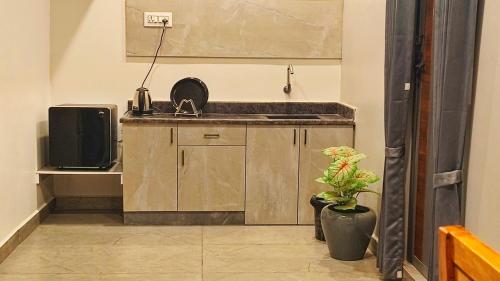 a kitchen with a sink and a tv in a room at KRS PARADISE premium suite room in Tiruvannāmalai