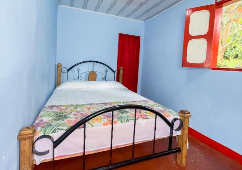 a bedroom with a bed and a red window at Ecohotel Bellavista Pance in Cali