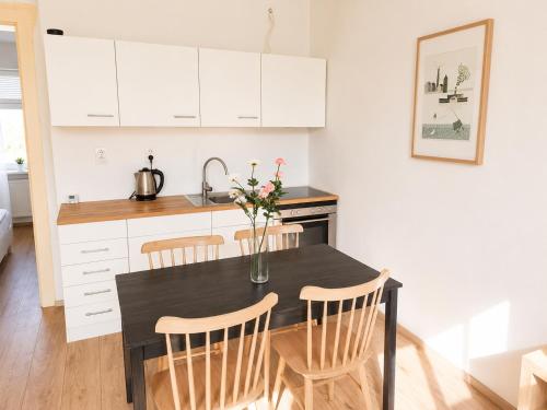 a kitchen with a black table with chairs and flowers at Villa Medica in Kraslice