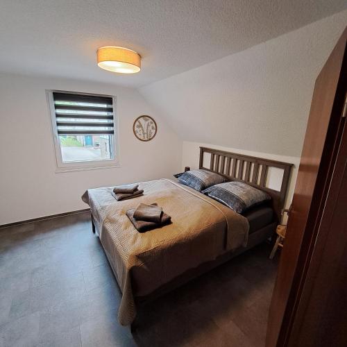a bedroom with a bed and a clock on the wall at Nest and Nature Strauch in Simmerath
