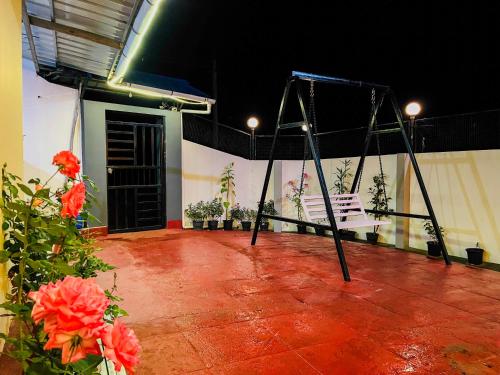 a swing in the middle of a room with flowers at Munnar Valley View in Munnar