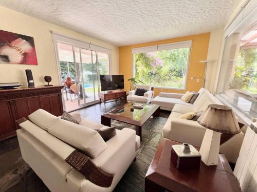 a living room with white couches and a tv at Mansión en Beverly Hills in Punta del Este