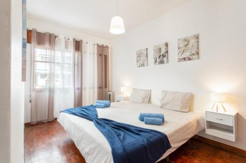 a bedroom with a large bed with blue pillows on it at Refúgio do Mar -Steps from the Beach- in Armação de Pêra