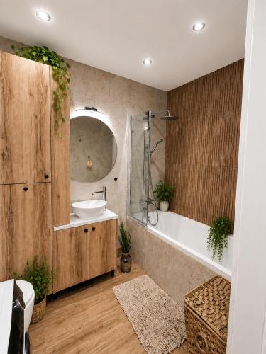a bathroom with a tub and a sink and a bath tub at Apartament Pod Modrzewiem in Augustów