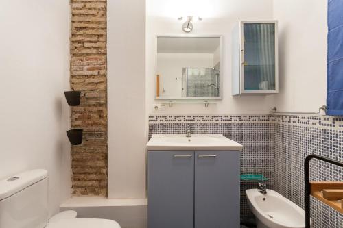 a bathroom with a sink and a toilet and a mirror at My Loft 4 You Borgia in Valencia