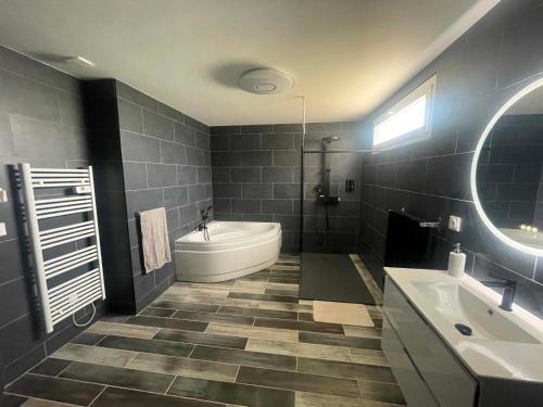 a bathroom with a tub and a toilet and a sink at Silver in Quessoy