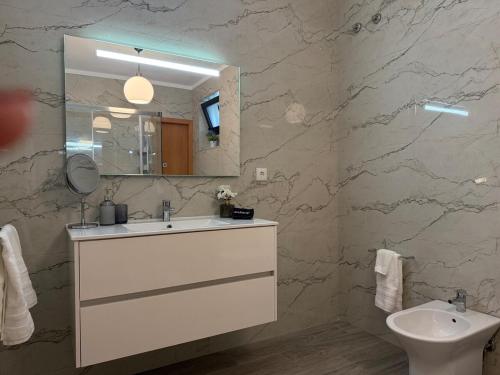 a bathroom with a sink and a mirror and a toilet at House overlooking the Douro-Casa das Almas in Paços de Gaiolo
