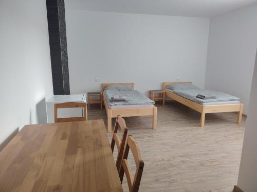 a room with two beds and a table and chairs at Ubytování Blažej in Týnec