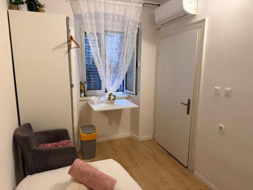 a bedroom with a bed and a chair and a window at Luxury rooms in Split