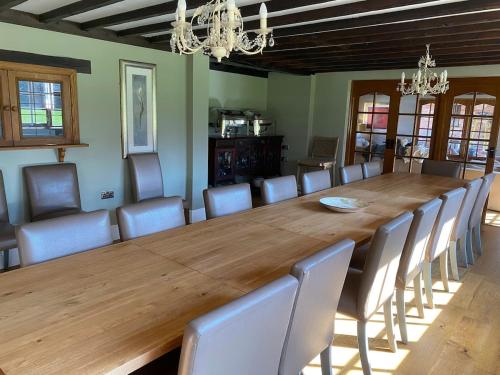 a dining room with a large wooden table and chairs at 8 BR Luxury Farmhouse | Tennis Court & EV Charging in Tile Hill