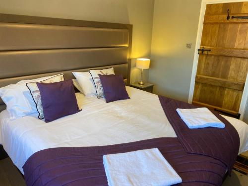 a bedroom with a large bed with two towels on it at 8 BR Luxury Farmhouse | Tennis Court & EV Charging in Tile Hill