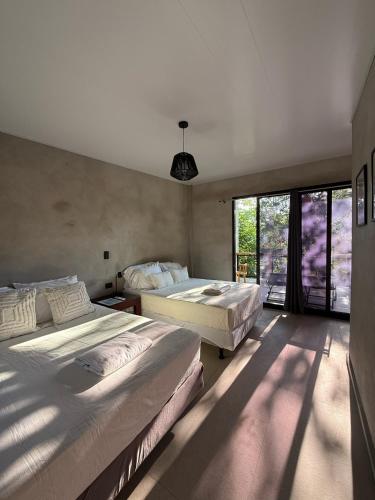 a bedroom with two beds and a large window at Shalpabay house - Private Apartments and Rooms in Taquillo