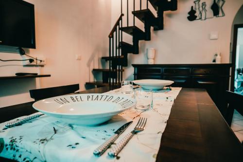 a dining room table with plates and silverware on it at Bixio 7 Boutique stay in Imola