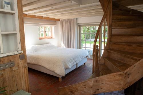 a bedroom with a bed and a large window at Vakantiehuis Lisette in Veurne