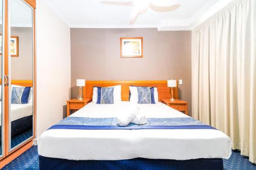 a bedroom with a large bed and a mirror at 2nd Floor 1-Bedroom Apartment in Urangan