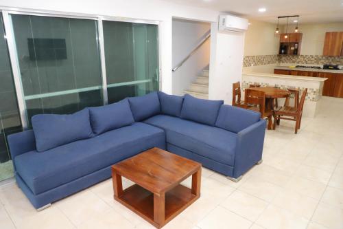 a blue couch in a living room with a table at Casa con alberca en el centro de Puerto Progreso in Progreso