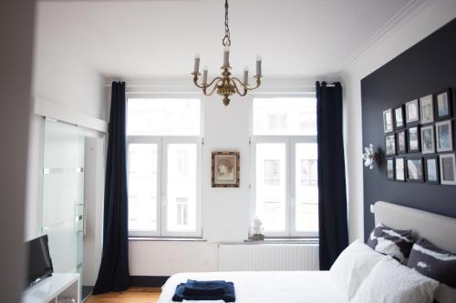 a bedroom with a white bed and white walls at B&B Villa 36 in Brussels