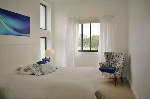 a bedroom with a bed and a chair and a window at JC Seaside in Vila Franca do Campo