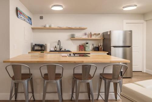 a kitchen with a counter and four bar stools at Modern Studio Downtown Anchorage in Anchorage
