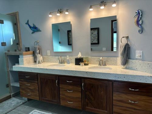 a bathroom with two sinks and two mirrors at Sunny Poolside Escape Near the Beach in Los Barriles