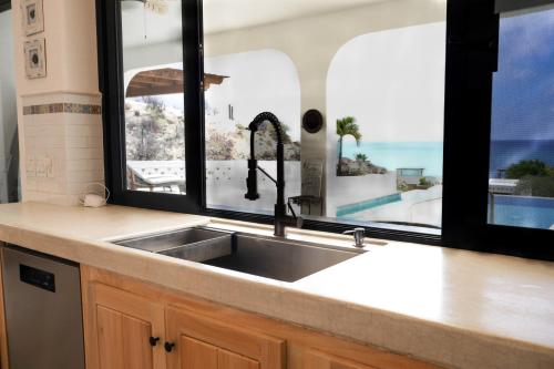 a kitchen with a sink and a view of a pool at Ocean Views Pool 2 Bedroom in Los Barriles