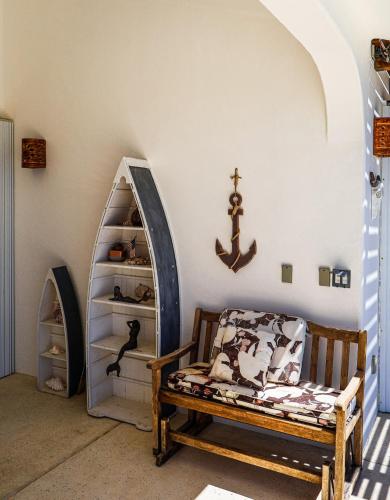a room with a chair and a shelf with a anchor on the wall at Ocean Views Pool 2 Bedroom in Los Barriles