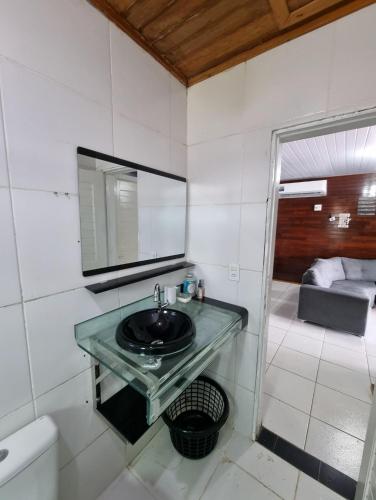 a bathroom with a sink and a mirror and a tub at Cabana do Parque in Presidente Figueiredo