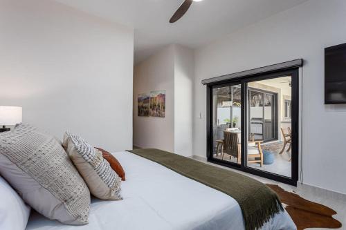 a bedroom with a large white bed with a window at Walkable Convenient in Downtown Los Barriles in Los Barriles