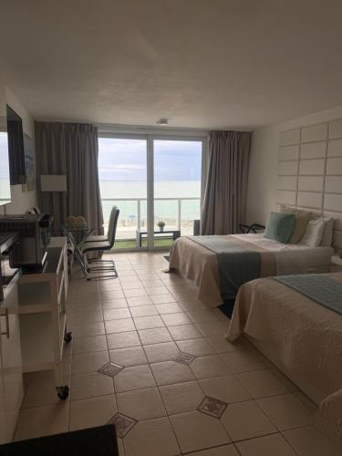 a hotel room with two beds and a view of the ocean at Ocean View Apartment In Sunny Isles in Sunny Isles Beach