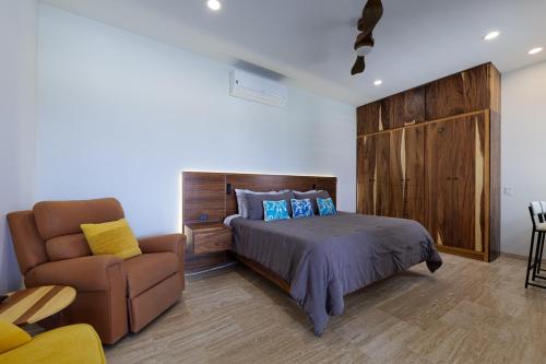 a bedroom with a bed and a chair at Seize the Day at Carpe Diem Condo in Los Barriles