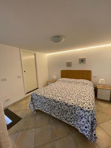 a bedroom with a bed with a black and white comforter at Lilli's House in Capri in Capri