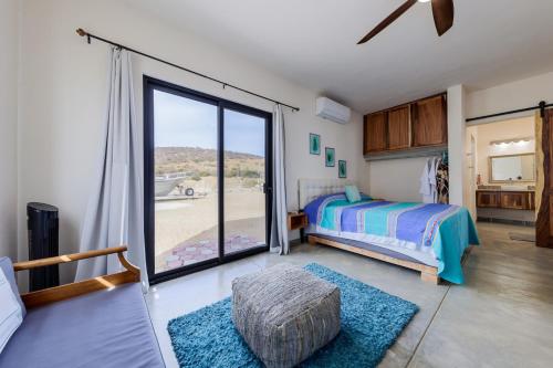 a bedroom with a bed and a large sliding glass door at Beachfront Pool, Rooftop Views & Baja Sunrise in Pescadero