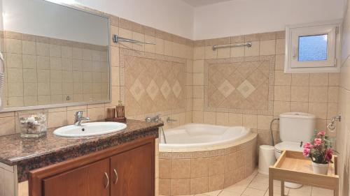 a bathroom with a tub and a sink and a toilet at Complex Summer Memories Souzan in Keramoti