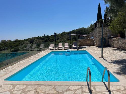 a swimming pool with blue water in a yard at Villa Ionis in Volímai