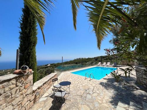 a pool with chairs and a view of the ocean at Villa Ionis in Volímai