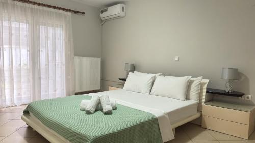 a bedroom with a bed with two towels on it at Complex Summer Memories Souzan in Keramoti