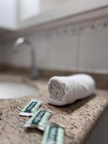 a towel sitting on top of a counter with two remote controls at Hotel Norte Sul in Campo Grande