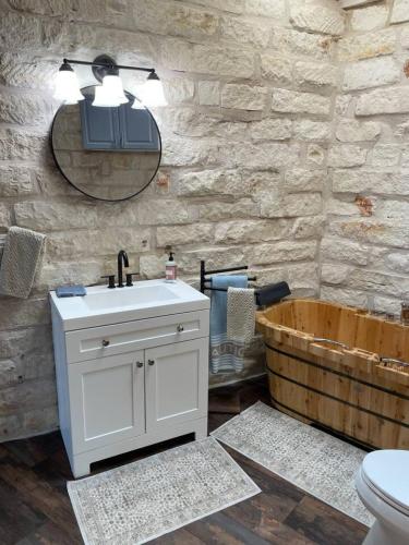 a bathroom with a sink and a wooden tub at The Cross Patio Retreat in Buda