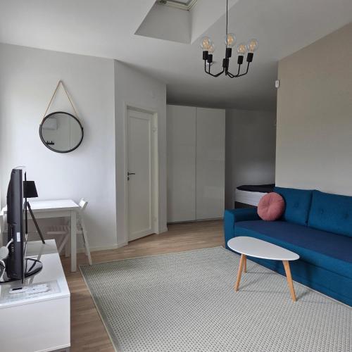 a living room with a blue couch and a table at Tiny Home in a Tiny Town in Hjärup