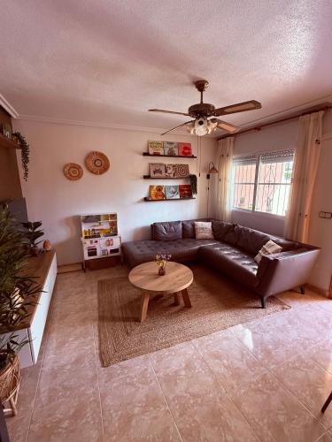 a living room with a leather couch and a table at Casa Midu Beachhouse 450m to the Beach in Los Alcázares