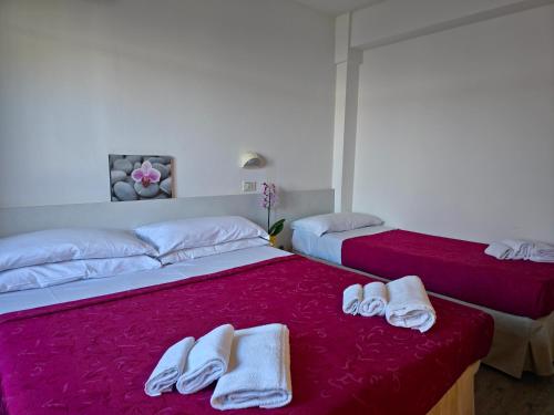 a bedroom with two beds with towels on them at Hotel Ornella in Bellaria-Igea Marina
